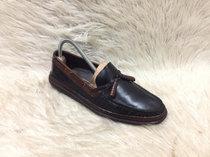 Brown leather loafer shoe on a white fur surface