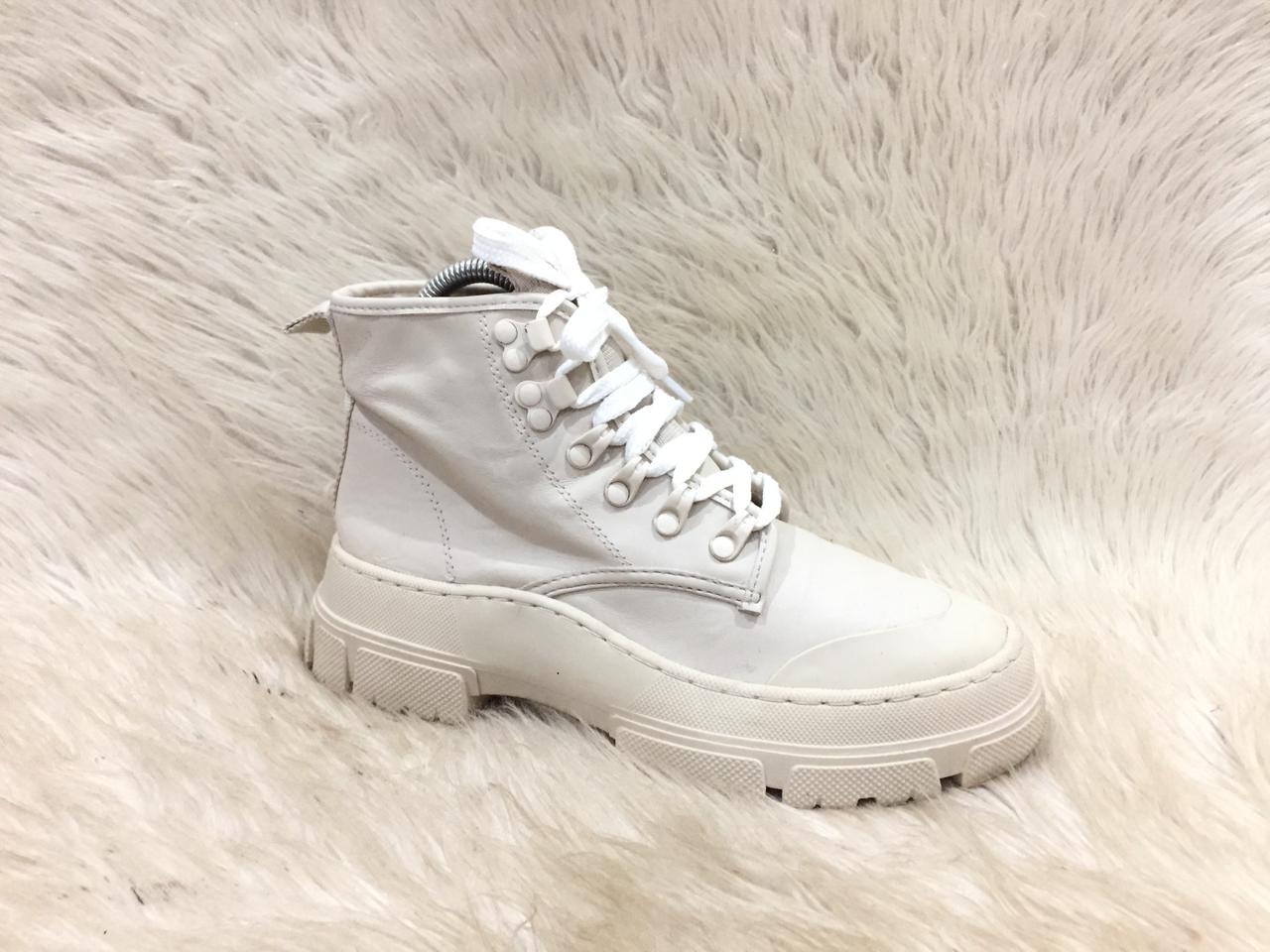 White high-top sneaker on a fluffy white surface