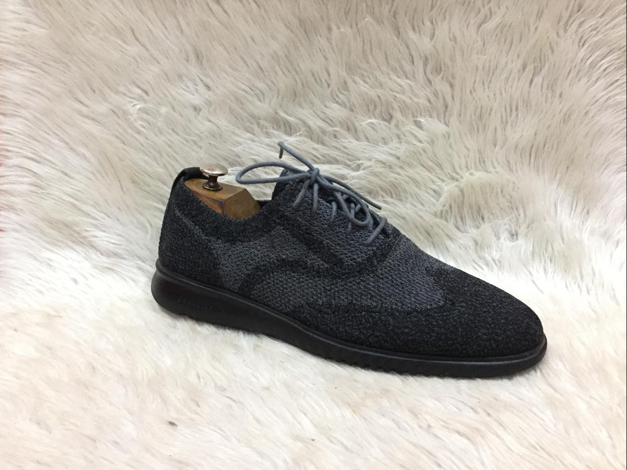 Black suede shoe on a white fur surface